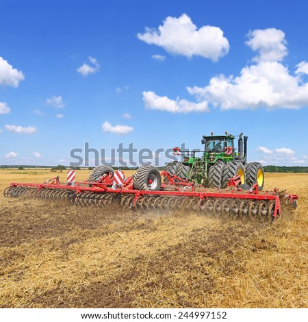Kalush, Ukraine - July 9: Modern John Deere tractor on soil treated cultivator in the field near the town Kalush, Western Ukraine July 9, 2013