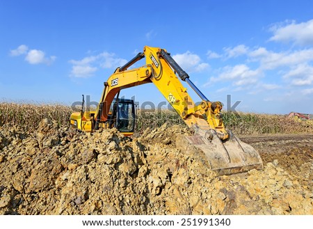 Kalush, Ukraine -October 7: Modern JCB excavator on the highway pipeline performs excavation work in the field near the town Kalush, Western Ukraine October 7, 2014