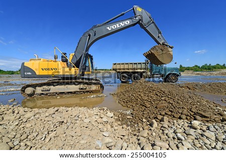 Kalush, Ukraine - July 22: Extracting and loading gravel excavated in the mainstream of the river near the town Kalush, Western Ukraine July 22, 2013