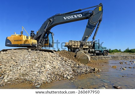 Kalush, Ukraine - July 22: Extracting and loading gravel excavated in the mainstream of the river near the town Kalush, Western Ukraine July 22, 2013