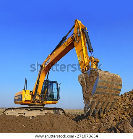 Kalush, Ukraine - October 14: Modern JCB excavator on the highway pipeline performs excavation work in the field near the town Kalush, Western Ukraine October 14, 2014