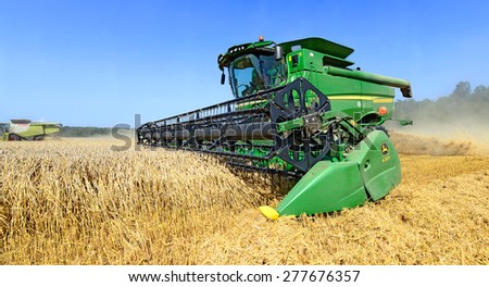 Kalush, Ukraine - AUGUST 11: Modern John Deere combine harvesting grain in the field near the town Kalush, Western Ukraine August 7, 2014