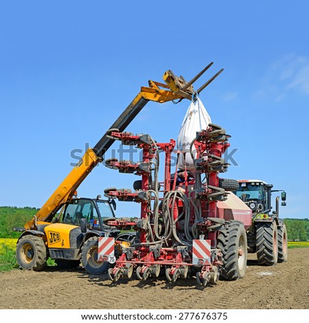 Kalush, Ukraine - May 10: Load grain into the hopper for sowing maize crop in the field near the town Kalush, Western Ukraine May 10, 2015