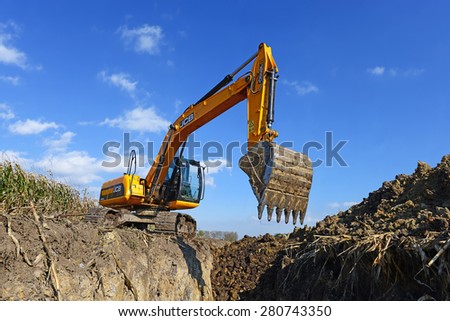 Kalush, Ukraine  October 7: Modern JCB excavator on the highway pipeline performs excavation work in the field near the town Kalush, Western Ukraine October 7, 2014