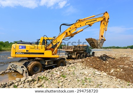 Kalush, Ukraine - July 8: Loading gravel in the car body on the construction of a protective dam near the town of Kalush, Western Ukraine July 8, 2015