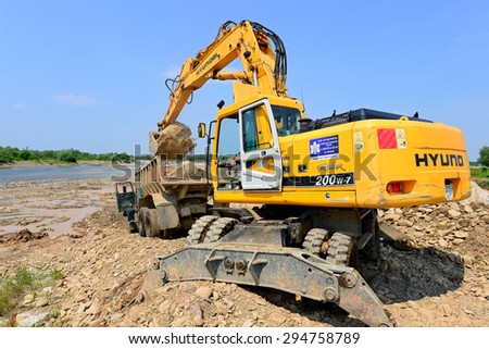 Kalush, Ukraine - July 8: Loading boulders in the car body on the construction of a protective dam near the town of Kalush, Western Ukraine July 8, 2015