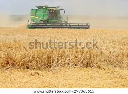 Kalush, Ukraine - AUGUST 17: Modern John Deere combine harvesting grain in the field near the town Kalush, Western Ukraine August 17, 2015