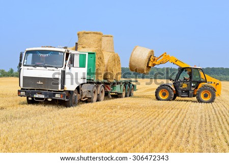 Kalush, Ukraine - August 14: Loading bales of straw on the car in the field near the town Kalush, Western Ukraine August 14, 2015