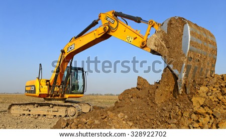 Kalush, Ukraine October 14: Modern JCB excavator on the highway pipeline performs excavation work in the field near the town Kalush, Western Ukraine October 14, 2014
