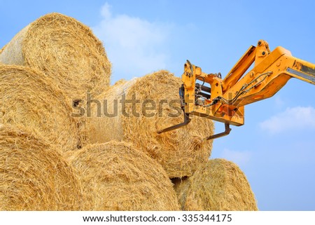 Telescopic handler for storing bales of straw on the ground storage