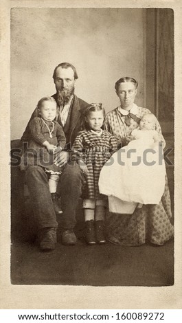 US - IOWA - CIRCA 1860 - A vintage Cartes de visite photo of a pioneer family of five. The mother and father are sitting with their three young daughters. A photo from the Civil War era. CIRCA 1860