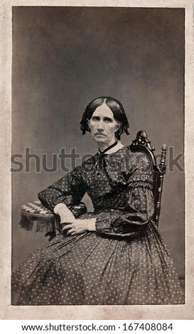 US -IOWA - CIRCA 1860 - A vintage Cartes de visite photo of an elderly woman dressed in a Victorian style hoop skirt dress.  She is sitting in a chair. A photo from the Civil War era. CIRCA 1860