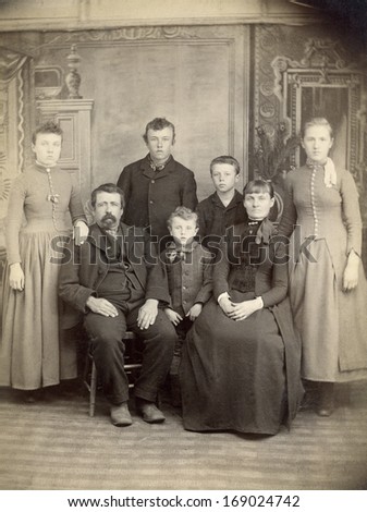 US - IOWA - CIRCA 1885 - A vintage antique photo of a family of seven. The mother and father are sitting with their five children standing behind. A photo is from the Victorian era. CIRCA 1885