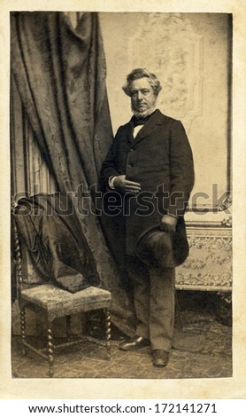 USA - NEW YORK - CIRCA 1862  A vintage Cartes de visite photo of an older gentleman with a beard and mustache. The man is standing next to a chair. A photo from the Civil War era. CIRCA 1862