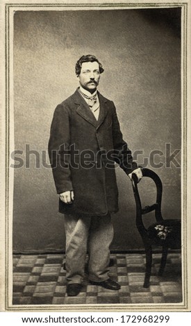 USA - NEW YORK - CIRCA 1865 - A vintage Cartes de visite photo of a gentleman. The man is standing with one hand on a chair. A photo from the Civil War Victorian era. CIRCA 1865