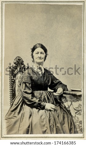 USA - WISCONSIN - CIRCA 1865 - A vintage Cartes de visite photo of older pioneer woman sitting in chair. She is dressed in hoop skirt dress.  Photo from the Civil War Victorian era. CIRCA 1865