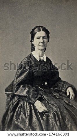 USA - OHIO - CIRCA 1865 - A vintage Cartes de visite photo of middle aged pioneer woman sitting in chair. She is dressed in hoop skirt dress.  Photo from the Civil War Victorian era. CIRCA 1865