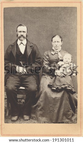 USA - NEW YORK - CIRCA 1865 A vintage Carte De Visite photo of a young pioneer family. The parents are sitting and the mother is holding baby. The photo is from the civil war Victorian era. CIRCA 1865