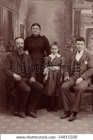 A 1800\'s antique vintage portrait photograph of a family posing for the camera. It is a studio formal photo of a Quaker family.