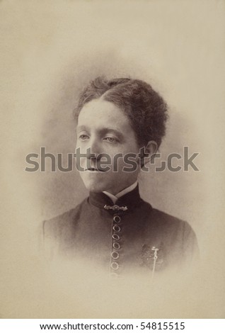 1800s Antique photograph of a woman from the eighteen hundreds. She wears the period style clothing and the photo is yellewed with age.