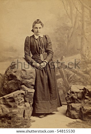 1800s Vintage portrait of a young girl. The photograph is yellowed with age. The young woman is dressed in the clothing of a Quaker religion.