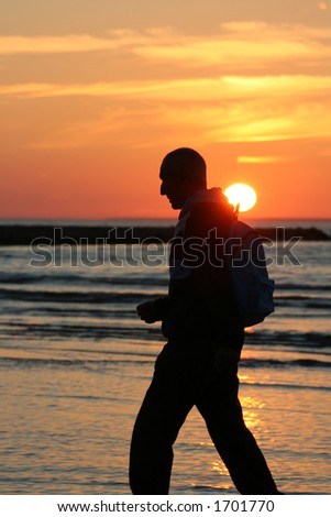 Old man walking at sunset