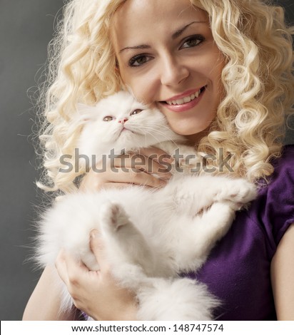 Beautiful young woman holding white Persian kitten