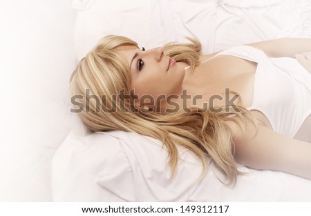 Beautiful young woman lying in bed