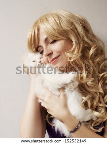 Beautiful young woman holding an adorable white Persian kitten