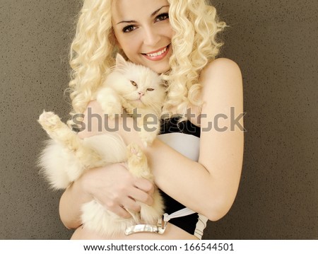 Pretty young woman holding a Persian kitten
