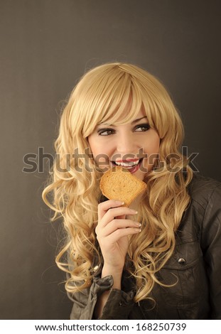 Pretty young woman eating a piece of toast