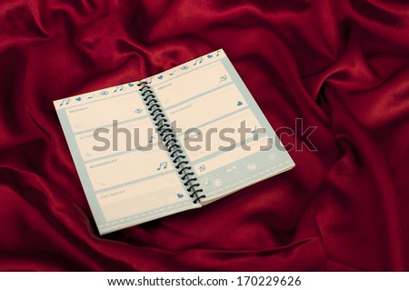 One planner notepad on a red satin sheet