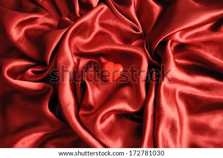Red heart on satin sheet