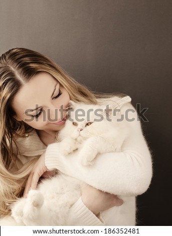Young woman holding a white fluffy Persian cat