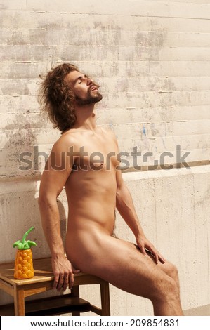 Handsome young nude man sunbathing
