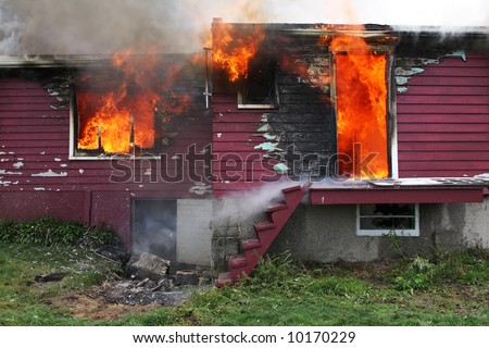 Abandoned house in fire with flames through the windows.  See many more fire and firefighters photo in my portfolio.
