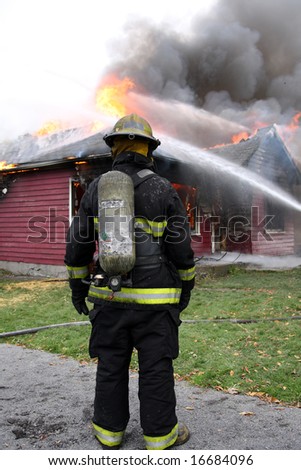 Disheartened fireman in front of a burning house