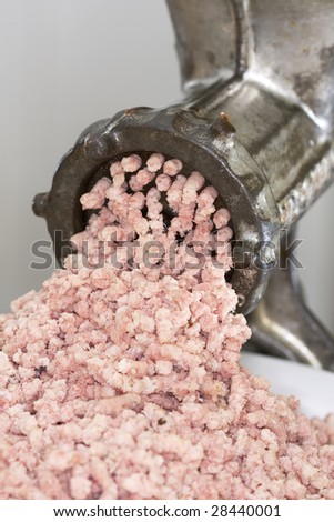 Close-up of a meat grinder in action, manually grinding ham