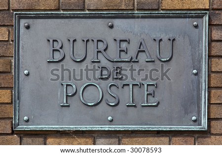 French post office sign made of brass and bolted on a brick wall