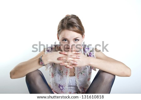young gorgeous woman staring at the camera with hands over mouth