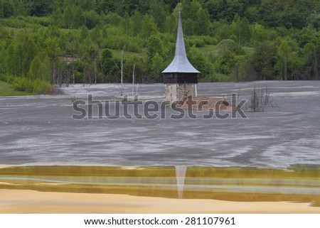 Flooded church in poluted mud lake in the mountains
