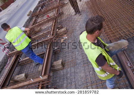 railway workers carrying metal on a construction site
