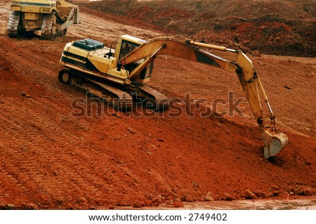 Power shovel excavating on a hillside of red clay