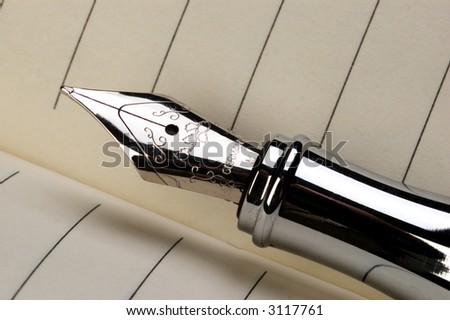 Extreme close-up of a fountain pen with lined journal paper in the background