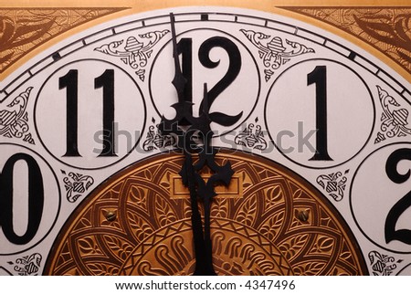 Close-up of the face of an old clock showing the time of one minute before twelve.