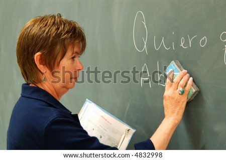 Female college professor erasing a chalkboard