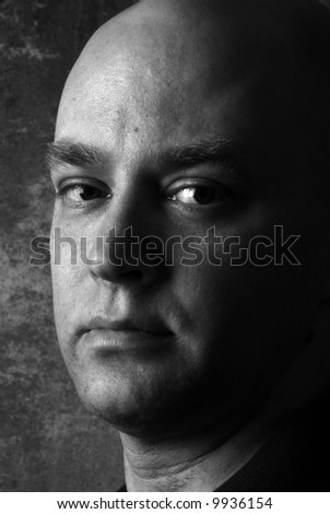 Black and white close-up portrait of a young man with a serious expression.