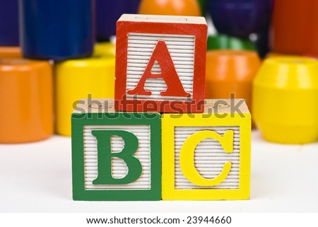 Closeup of three wooden alphabet blocks in a pyramid spelling \