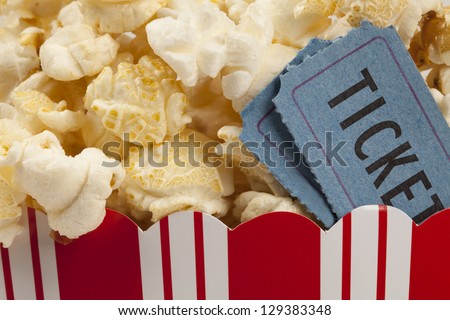 close up of two tickets stubs in a box of popcorn. Concept of movie time.