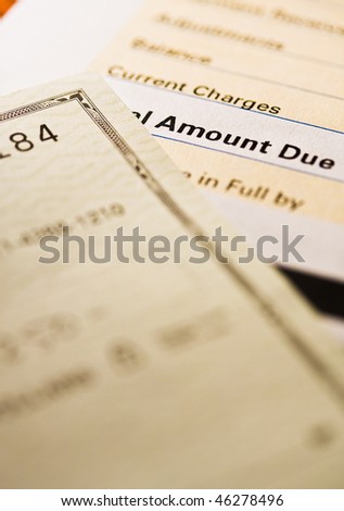 A personal check on top of a credit card statement with selected focus.
